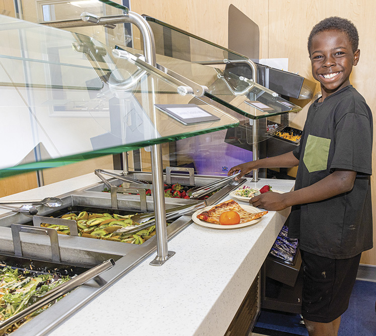 Student Jackson Reed gets lunch at Sierra Vista School in Vacaville, which buys produce, including oranges from California farms.